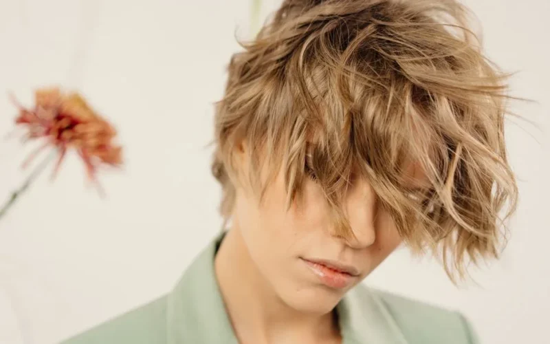 Stylish woman with tousled short hair and neutral expression.