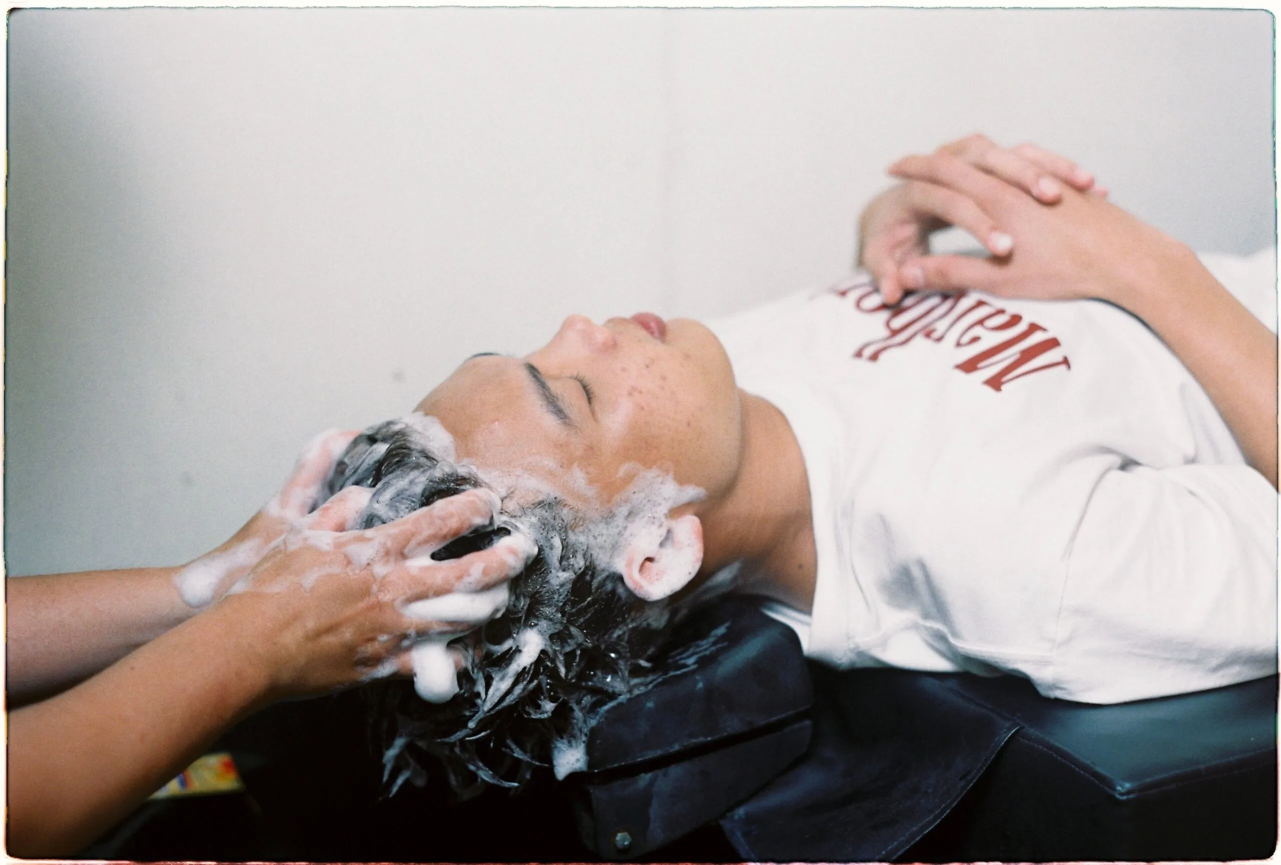 A person enjoying a soothing hair wash in a salon setting, conveying relaxation.