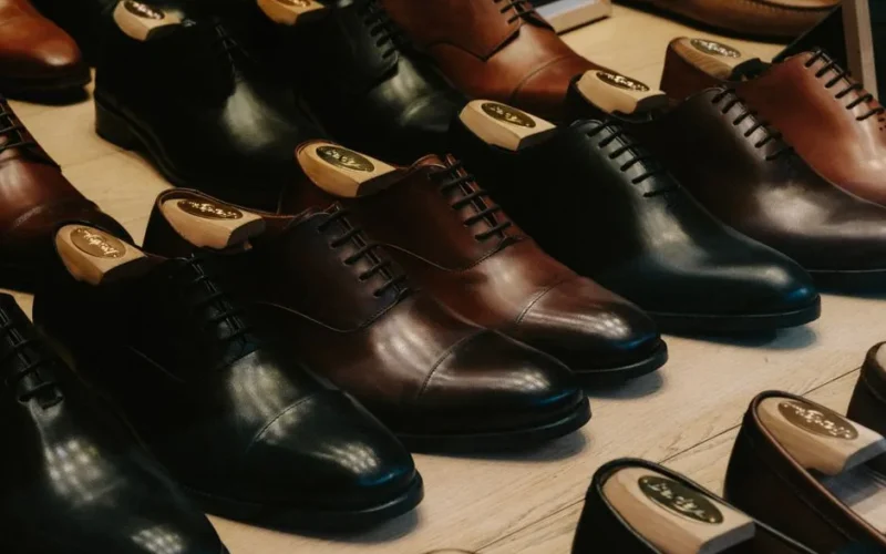 Close-up of luxury leather shoes arranged neatly in a store for sale.