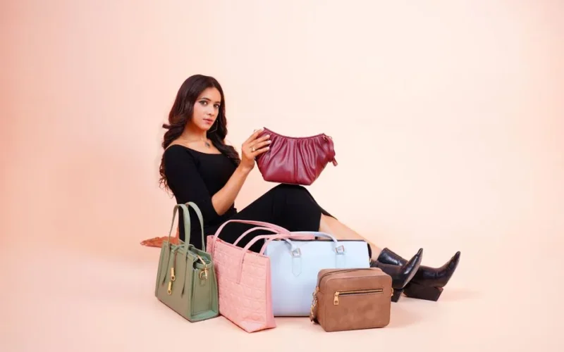 Stylish model showcasing a collection of designer handbags in Lahore.