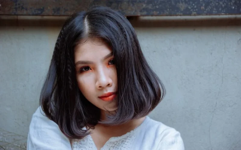 Close-up photo of a young Asian woman with styled hair and makeup, showcasing beauty and elegance.