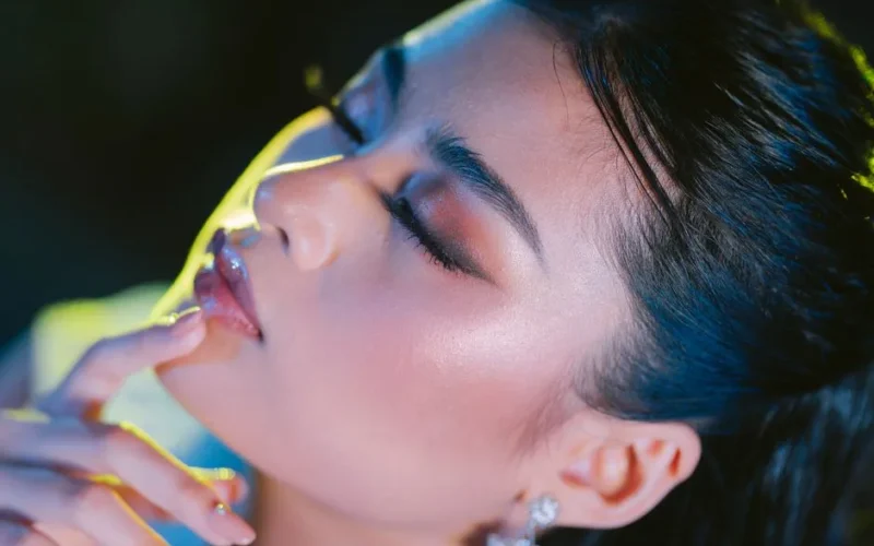 Close-up portrait of a young woman with glamorous makeup, eyes closed, exuding elegance and beauty.