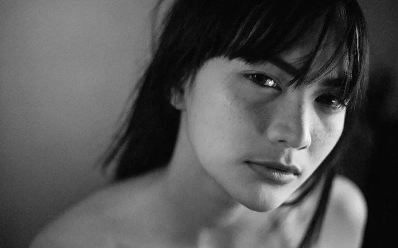 Close-up black and white portrait capturing natural beauty and expression of a woman.