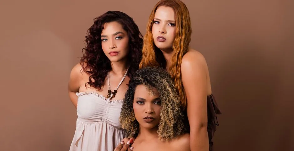 A portrait of three diverse women in elegant attire with stylish hairstyles.